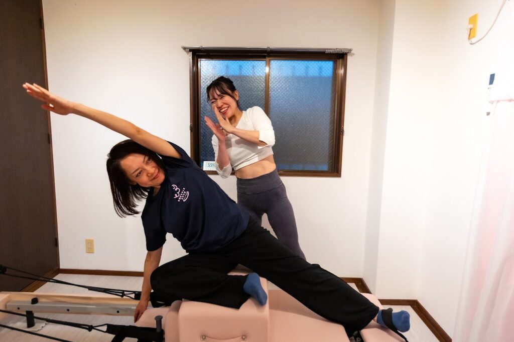 リフォーマーを使って指導するピラティスインストラクター